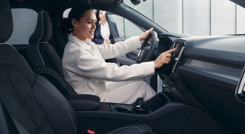 Une femme assise au volant effectue la prise en main de son véhicule