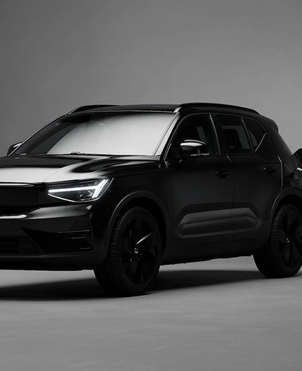 EX40 Black Edition en charge dans une pièce minimaliste, faiblement éclairée, aux murs et sol gris