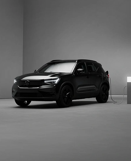 EX40 Black Edition en charge dans une pièce minimaliste, faiblement éclairée, aux murs et sol gris