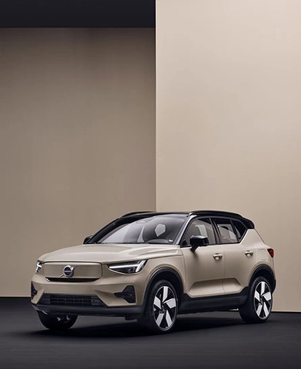 Volvo EX40 beige garé dans une pièce minimaliste aux murs beiges et sol noir