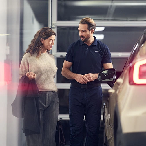 Dans un atelier Volvo, un technicien échange avec une cliente et lui présente le programme Les privilèges V+