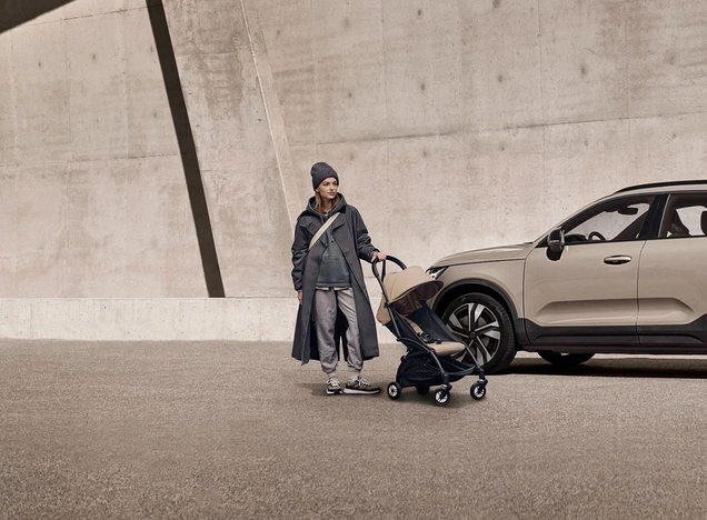 Femme avec une poussette à coté du XC40
