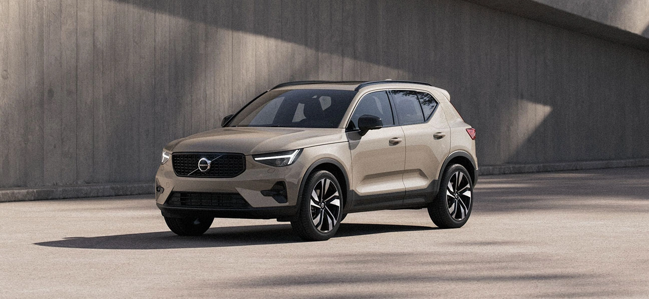 Volvo XC40 beige stationné en extérieur, avec un mur en béton en arrière-plan