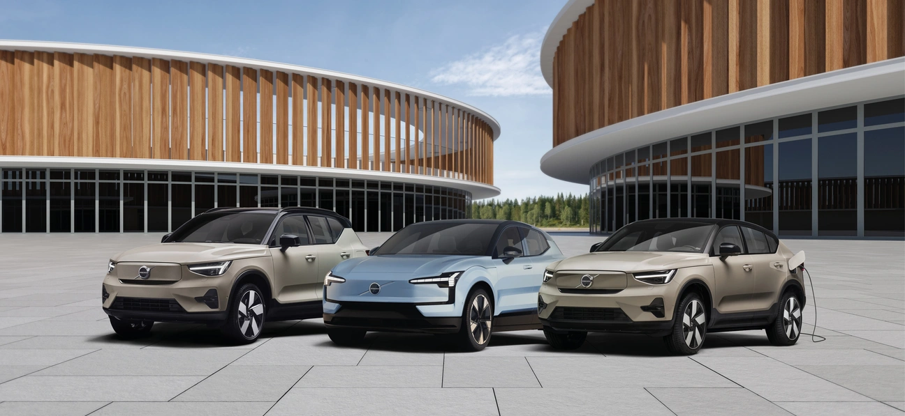 Gamme Volvo électrique : trois modèles inspirants devant une architecture en bois moderne, alliance parfaite entre nature, design et avenir durable.