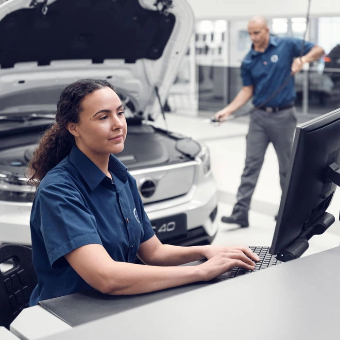 Une technicienne Volvo devant un ordinateur dans un atelier Volvo