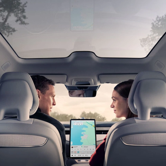 Vue intérieure de l'ES90 avec toit panoramique. Un homme au volant et une femme à ses côtés