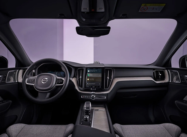 Vue intérieure d’une Volvo moderne avec volant, tableau de bord et écran tactile central.